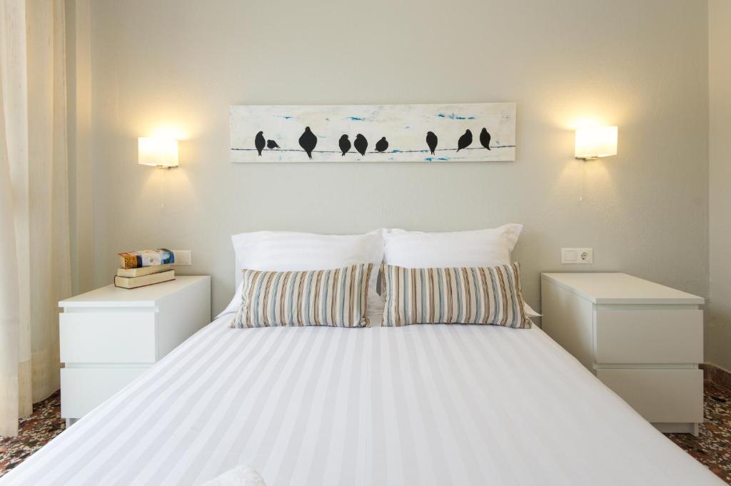 奥林匹亚基·阿克蒂Sonnenhaus的一间卧室配有一张带2个床头柜的大型白色床