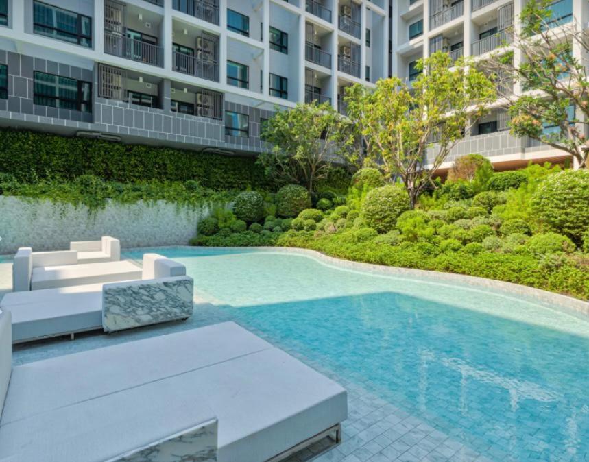华欣DusitD2 Hua Hin - One bedroom with a beautiful view of the garden and pool的大楼前的游泳池