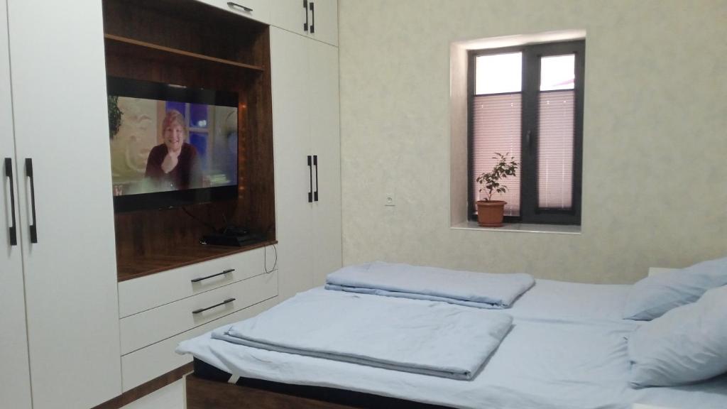 撒马尔罕Begzod's house的一间卧室配有两张床和一台平面电视