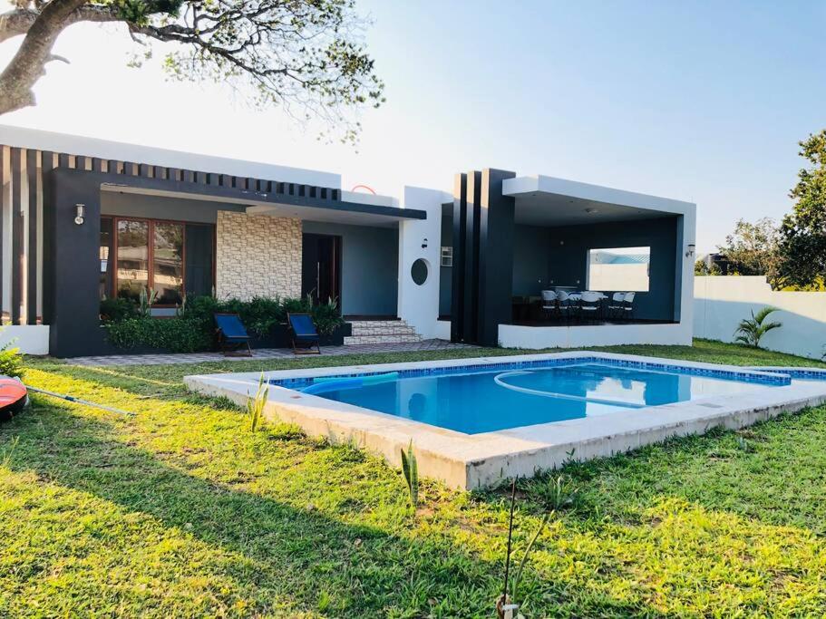 蓬塔杜欧鲁Ponta d’ ouro lia’s house的庭院中带游泳池的房子