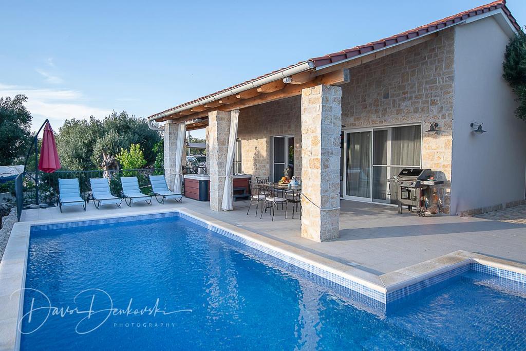 伦Island Villa Adriana with heated pool and sauna的房屋前的游泳池