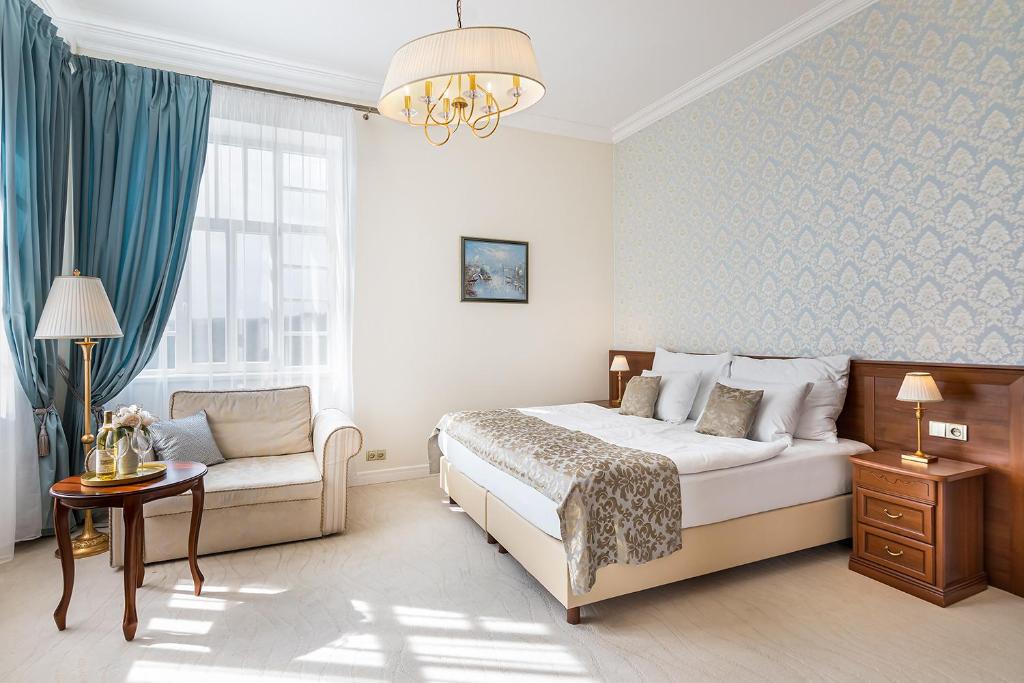 兹诺伊莫Hotel Katerina的一间卧室配有一张床、一张沙发和一个窗口