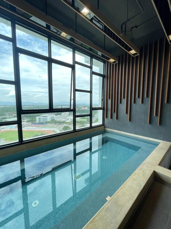 是拉差Seaview condo in Siracha (Free onzen)的一座带窗户的建筑中的游泳池