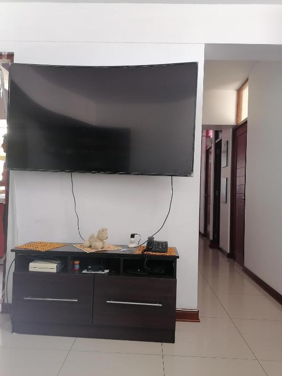 齐克拉约Residencial Las Torres de Salaverry的挂在墙上的大屏幕平面电视