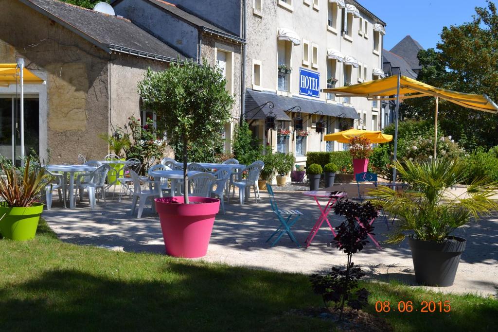 Brissac-Quincé乐卡斯特酒店的一个带桌椅和盆栽的庭院