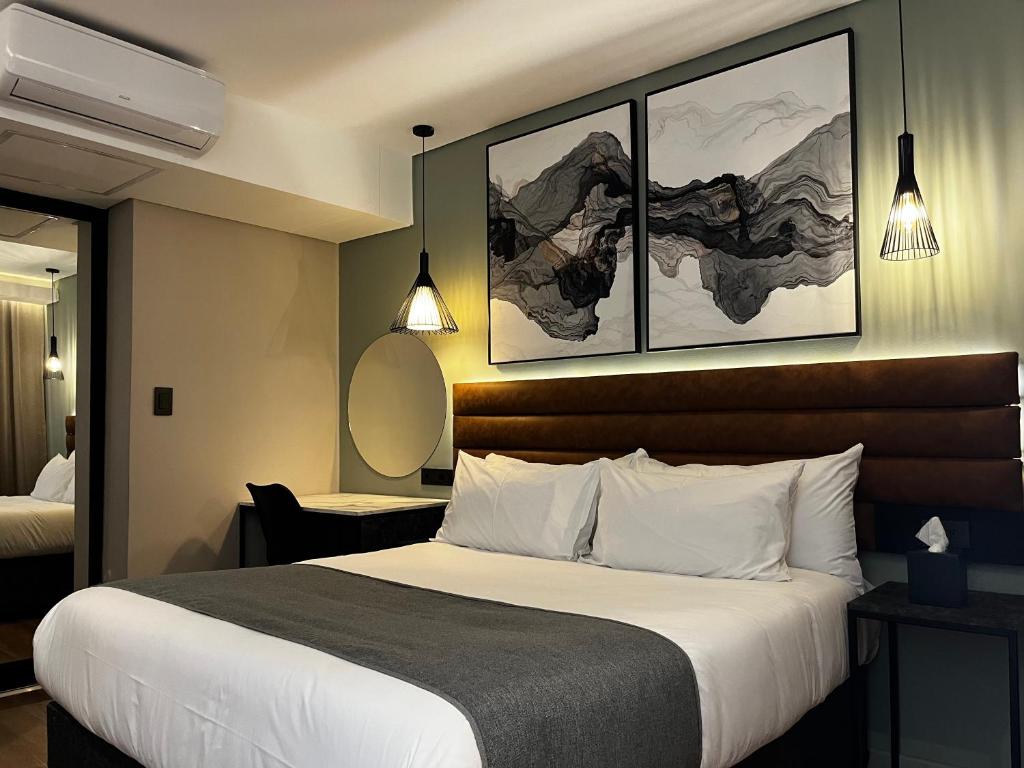 布里茨Riverleaf Hotel的酒店客房,配有一张床,墙上挂有两张照片