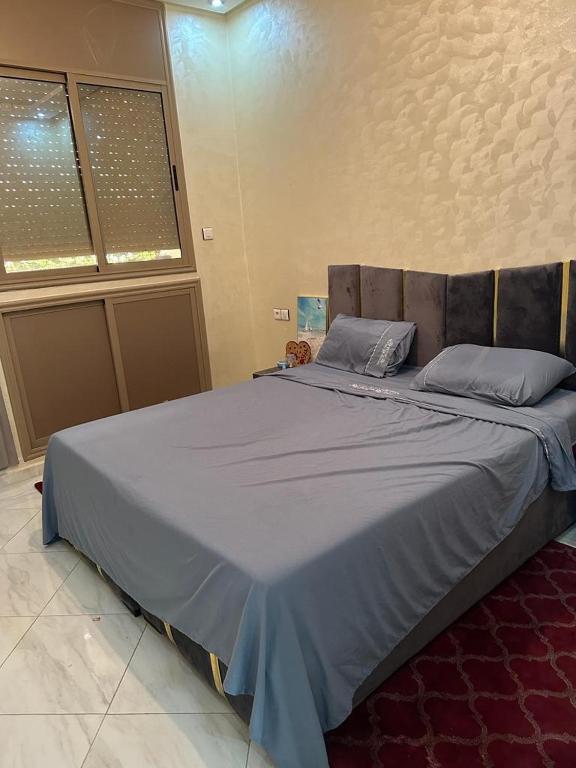 Derouaplanets house的一间卧室配有一张带蓝色床单的大床