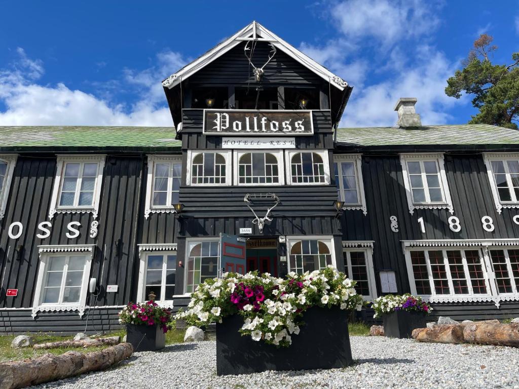 SkjåkPollfoss Hotell的前面有鲜花的黑色建筑