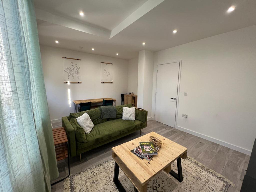 伦敦Lovely 1-bedroom flat with Patio的客厅配有绿色沙发和桌子