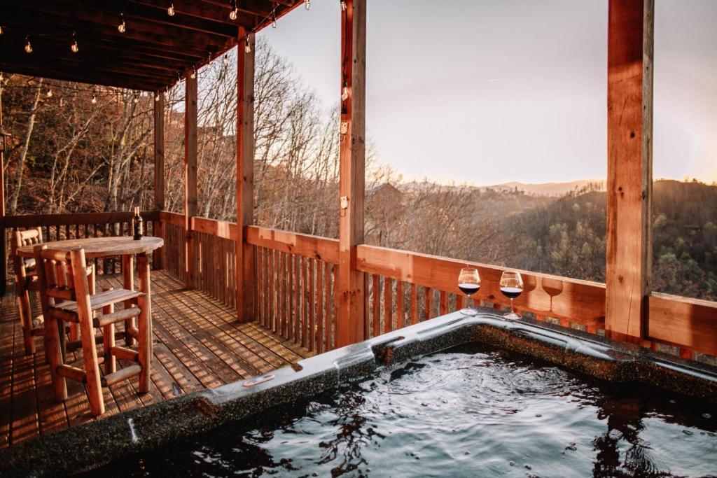 赛维尔维尔Expansive Mountain Views, Theater, Games, Hot Tub, Relaxing porches的小屋甲板上的热水浴池