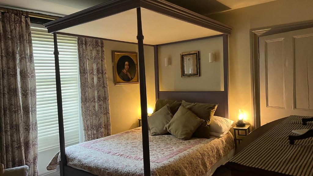 布里克瑟姆HORTUS HOUSE - Regency style apartment with attached parking的一间卧室配有一张四柱床和天蓬