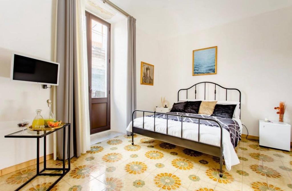 卡塔尼亚4Tino的一间卧室配有一张床、一张桌子和一个窗户。