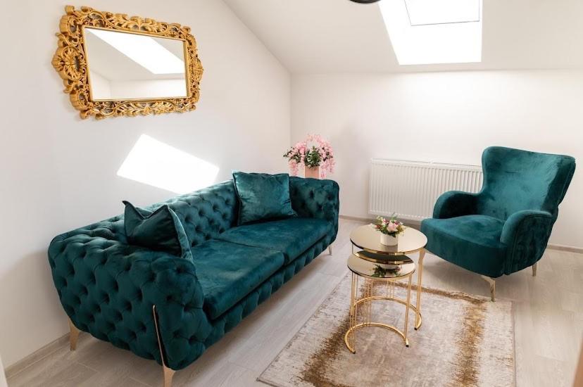 布尔奇科Legato Apartment的客厅配有绿色沙发和两把椅子