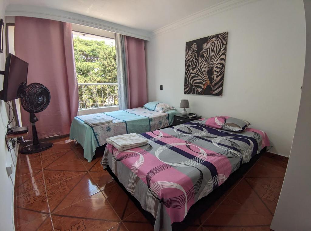 卡利Hospedaje Casa Aurora的带窗户的客房内的两张床