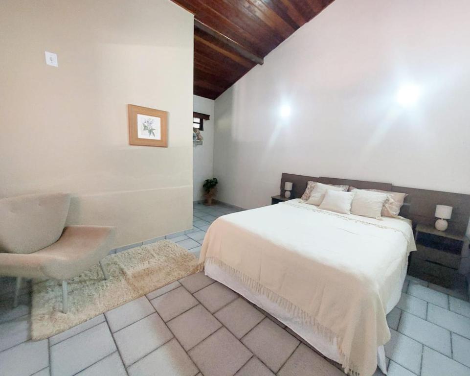 伊皮亚巴斯La Remonta Residence的一间卧室配有一张床和一把椅子