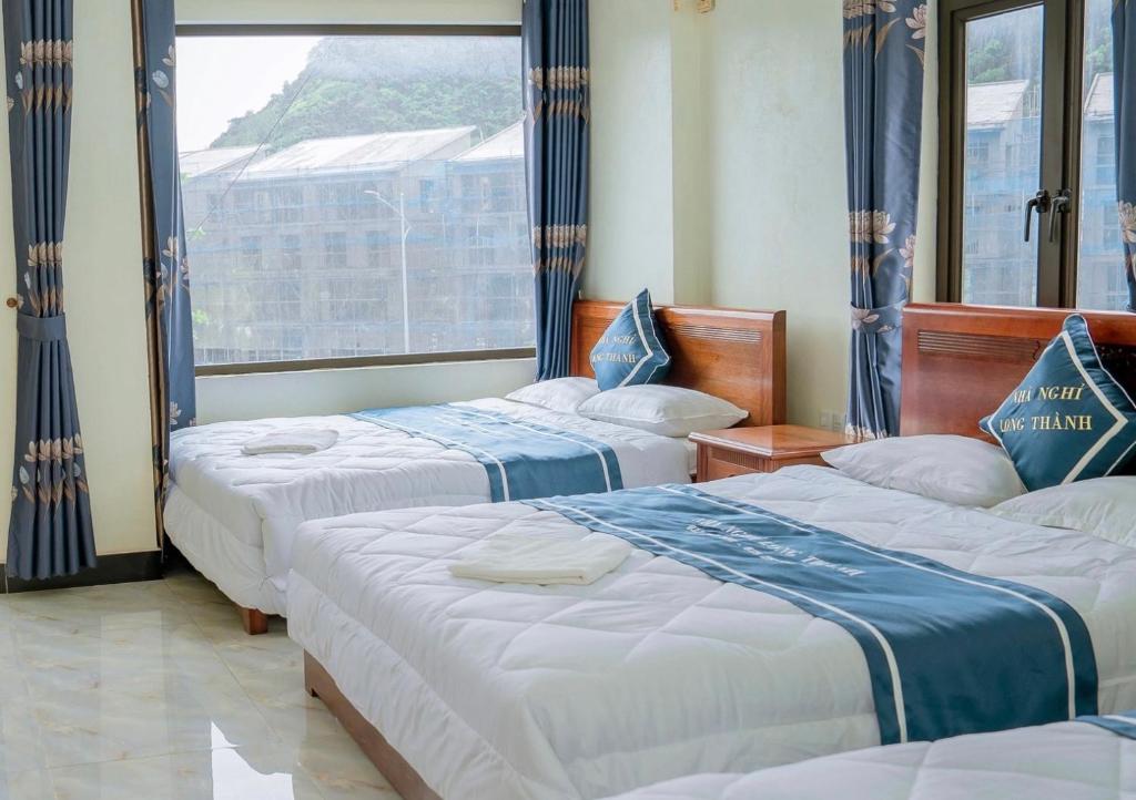 吉婆岛Long Thành Motel的酒店客房设有三张床和窗户。