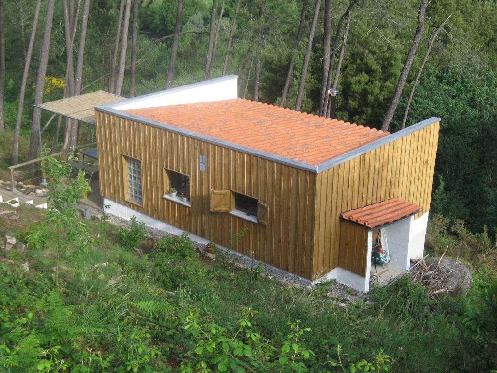 蓬蒂-达巴尔卡Casa Do Pinheiral的森林中一座带橙色屋顶的小房子