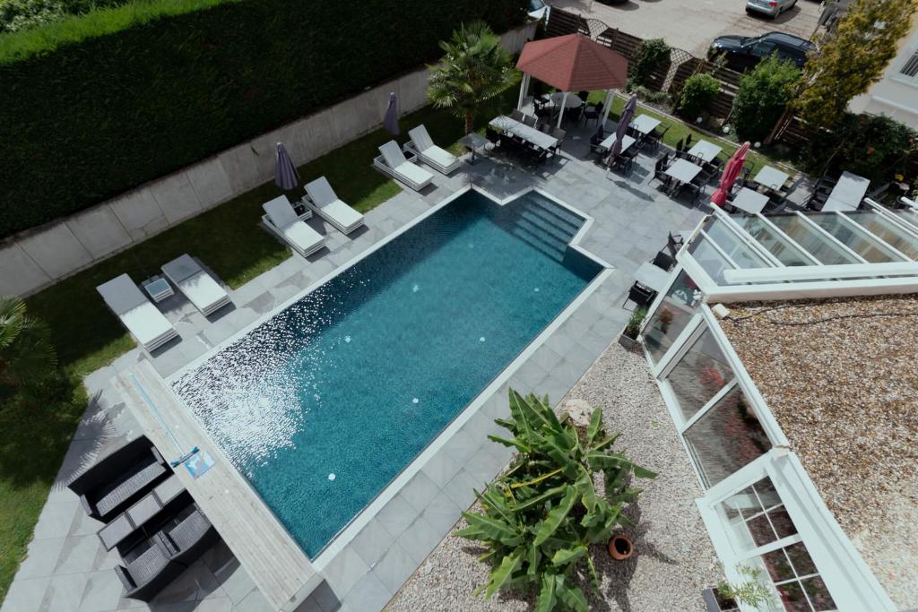 鲁斯特Hotel Andante Rust的享有带椅子和遮阳伞的游泳池的顶部景致