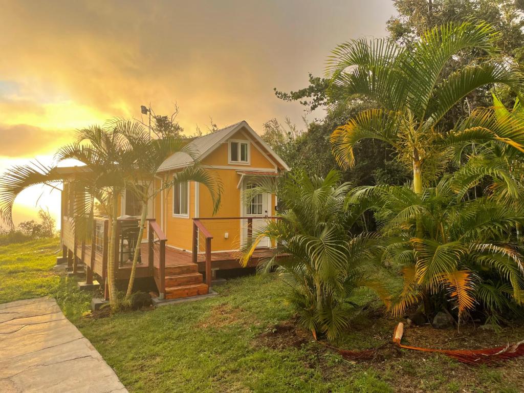 Papa Bay EstatesCountry Cottage in Papa Bay的树中间的一个小黄色房子