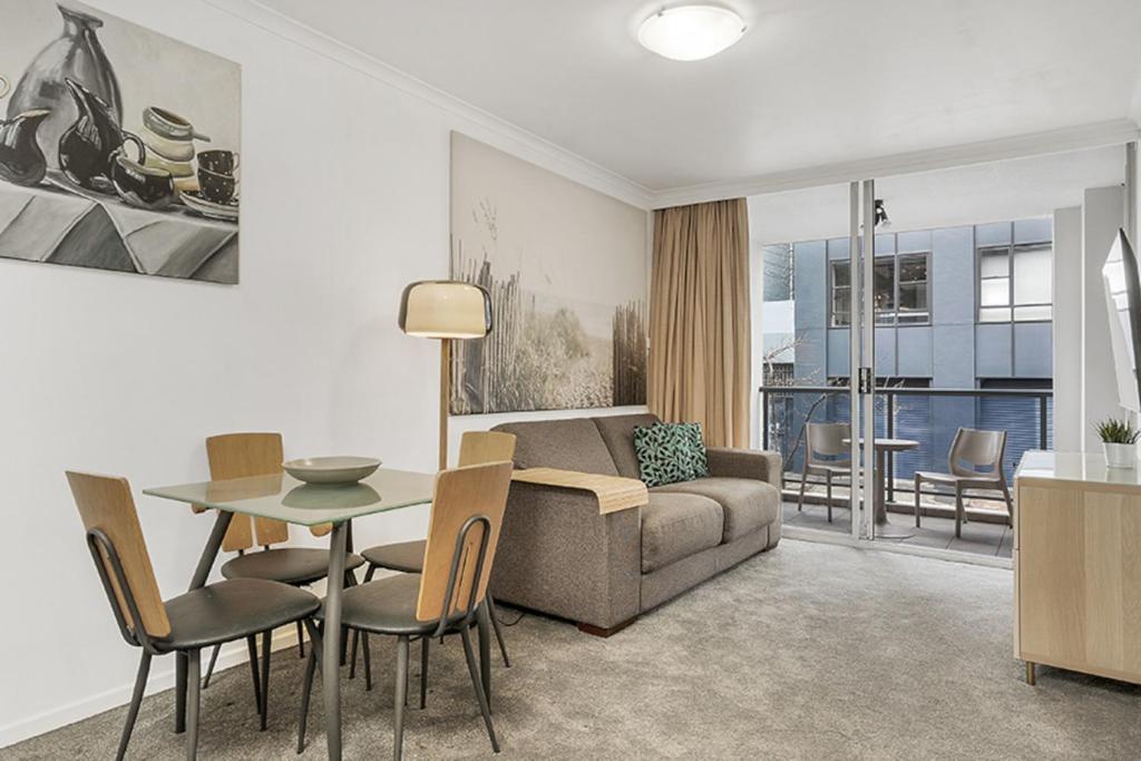 悉尼Contemporary Apartment的客厅配有沙发和桌椅