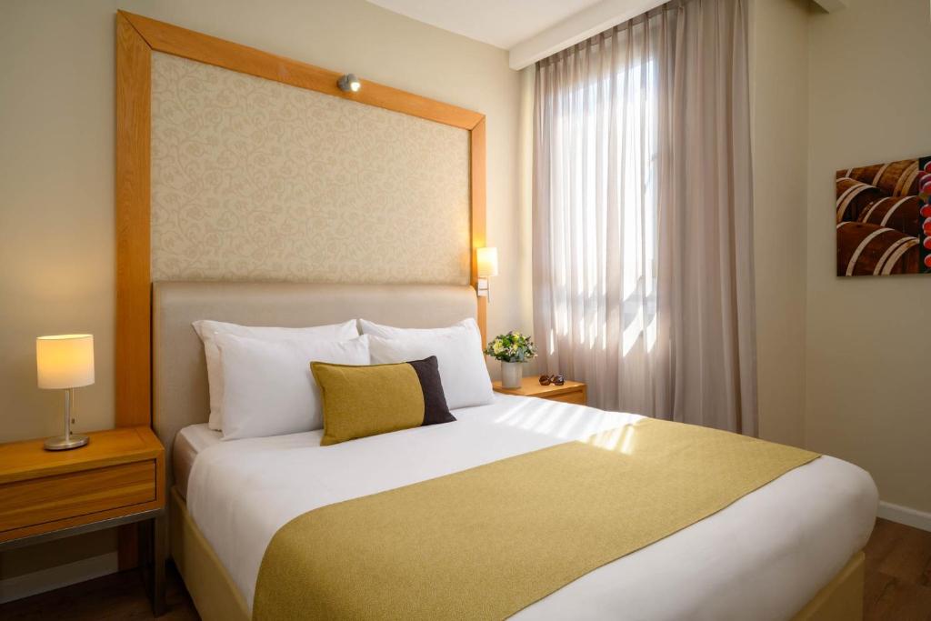 耶路撒冷耶路撒冷普瑞玛公园酒店 的一间卧室设有一张大床和一个窗户。