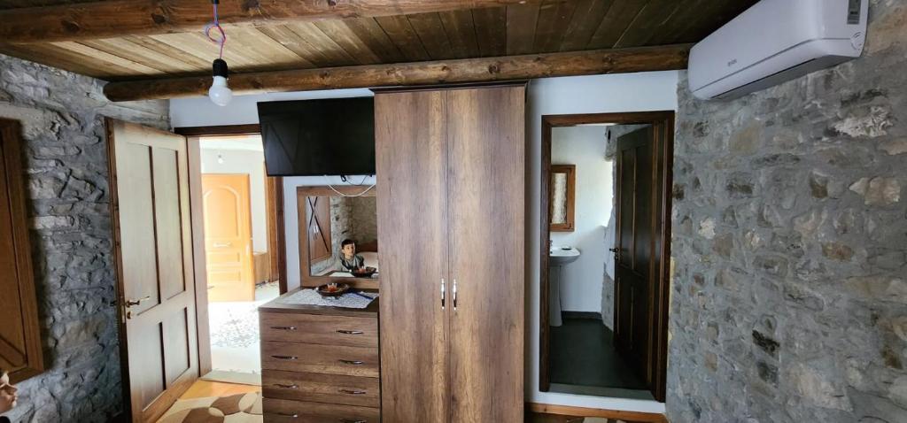 吉诺卡斯特Villa Shuaipaj的一间带木制橱柜和镜子的浴室