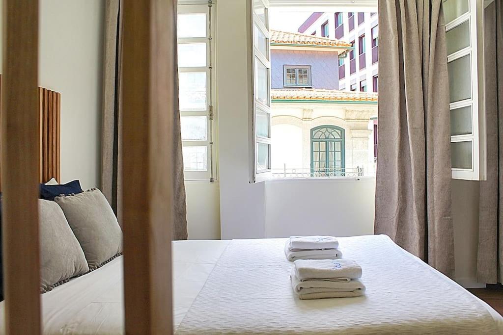 波尔图Oporto Sweet Downtown 5的一间卧室配有带毛巾的床