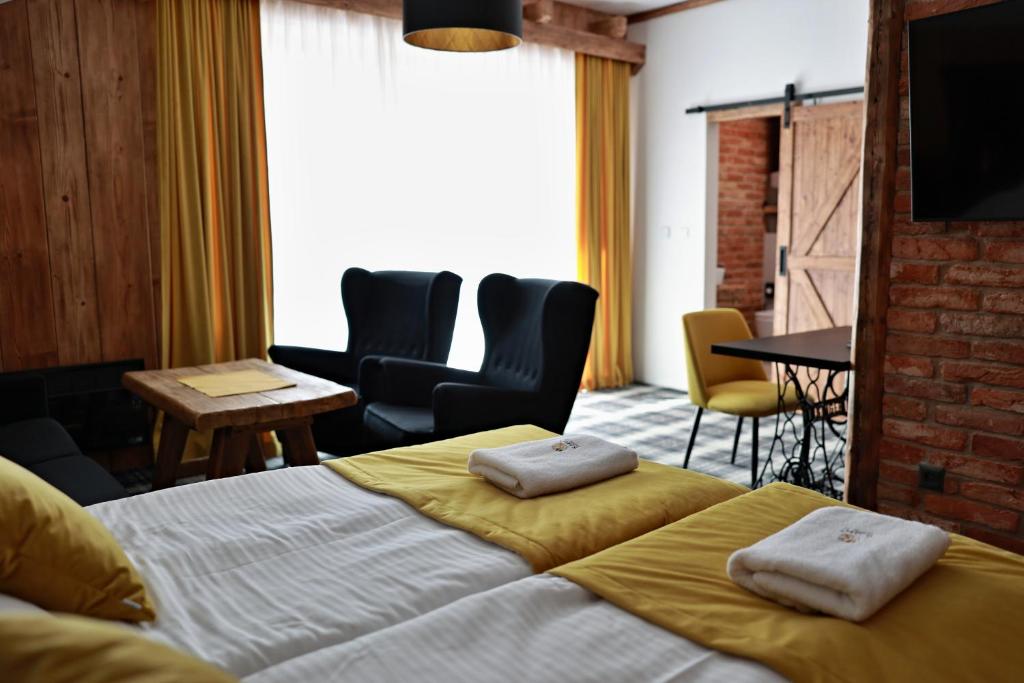 RegetovkaRanč Regetovka的一间卧室配有一张床铺和椅子以及一台电视。