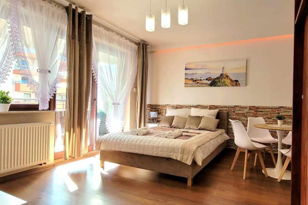 克拉科夫Modern Apartment SANDY BEACH down town, aquapark, free parking的卧室配有一张床和一张桌子及椅子