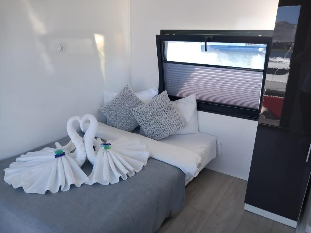 HrdoňovHausboat David的一间卧室配有一张带白色床单的床和一扇窗户。