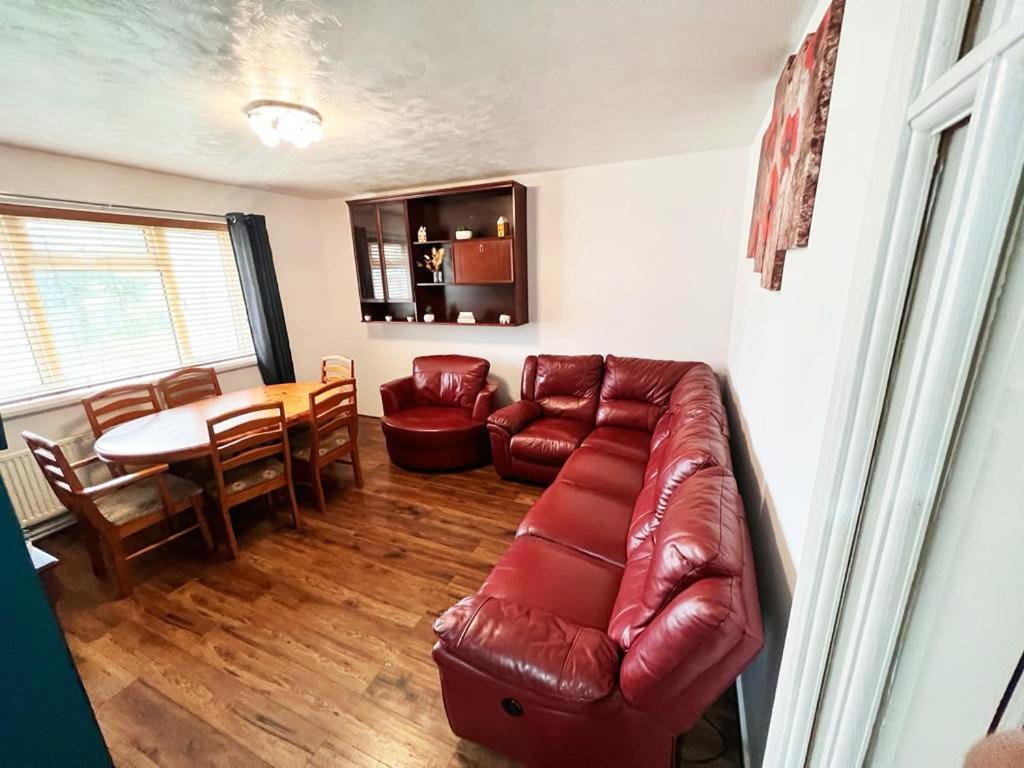 伯明翰Private Rooms with Shared Kitchen & Bathroom - Birmingham的客厅配有红色皮革沙发和桌子