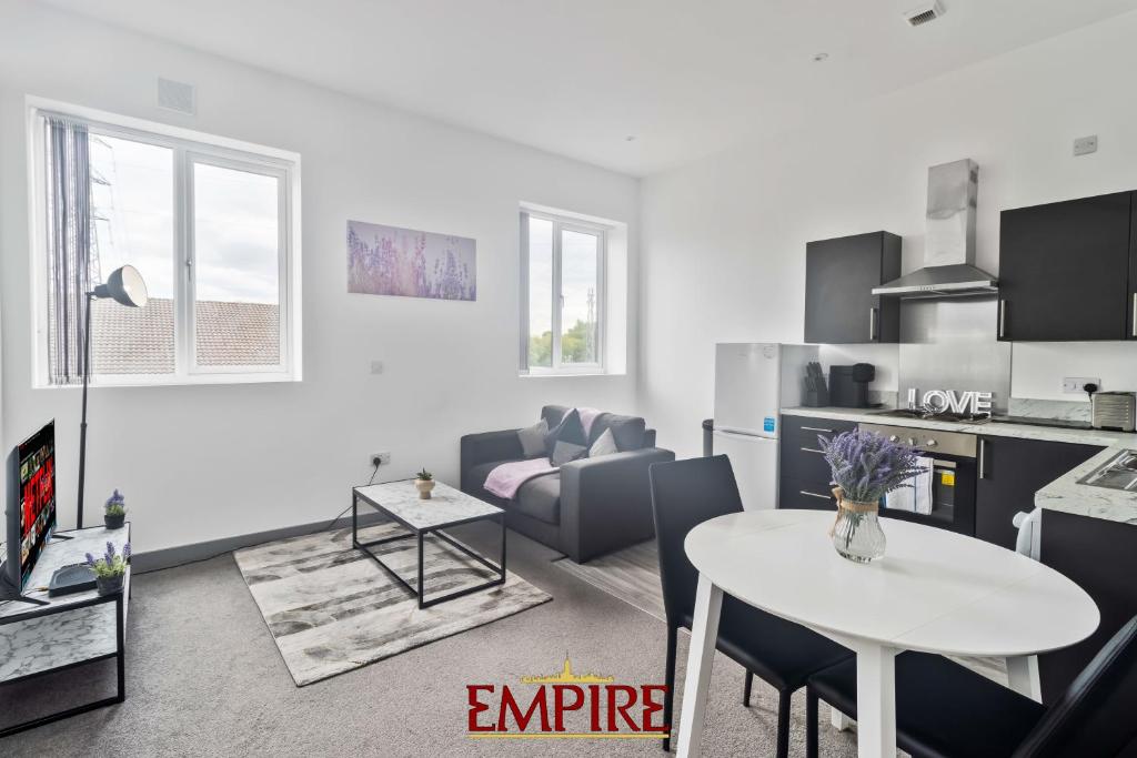 布赖尔利希尔Modern One Bedroom Apartment Brierley Hill的白色的客厅配有桌子和厨房