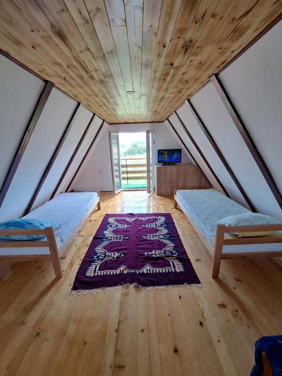 兹拉蒂博尔Vikendica Velanac的一间设有两张床的客房,地板上铺有地毯。