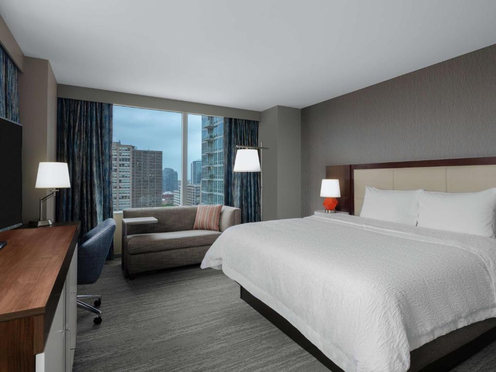芝加哥芝加哥麦考密克广场汉普顿酒店的酒店客房设有一张大床和一张沙发。