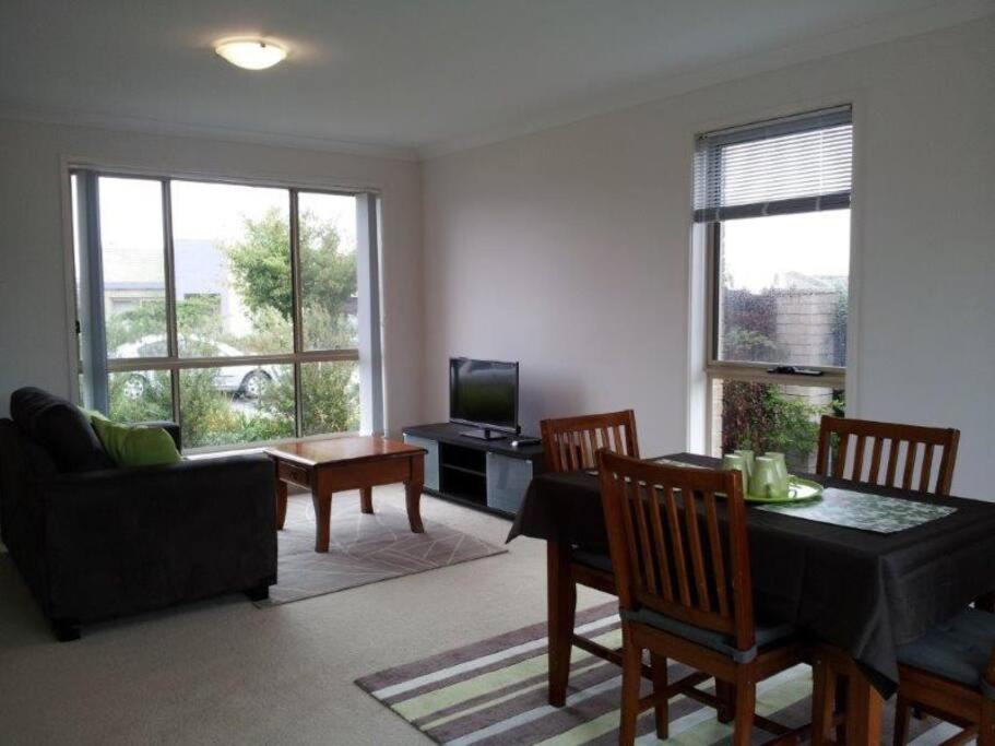 堪培拉Entire 2BR sunny house @Franklin, Canberra的客厅配有桌椅和电视。