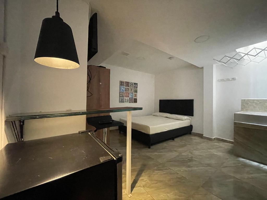 麦德林Apartamento con aire acondicionado al lado de la Unidad Deportiva de Belén y a 10 minutos de Plaza Mayor - 2的卧室配有一张床和一张桌子