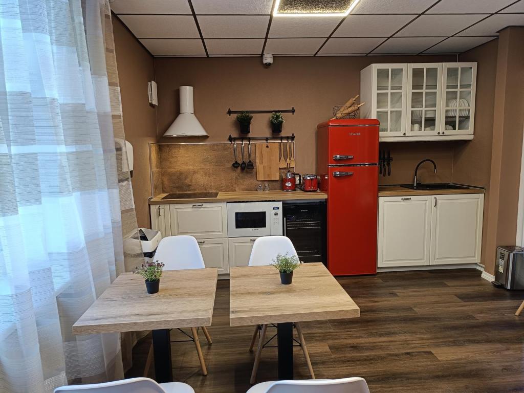 纳尔瓦APARTHOTEL的厨房配有桌子和红色冰箱