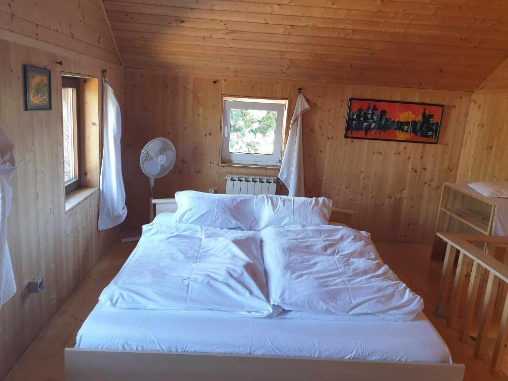 阿特尔高地区圣格奥尔根Homestay Sleepy Traveler的木制客房内的一间白色床卧室
