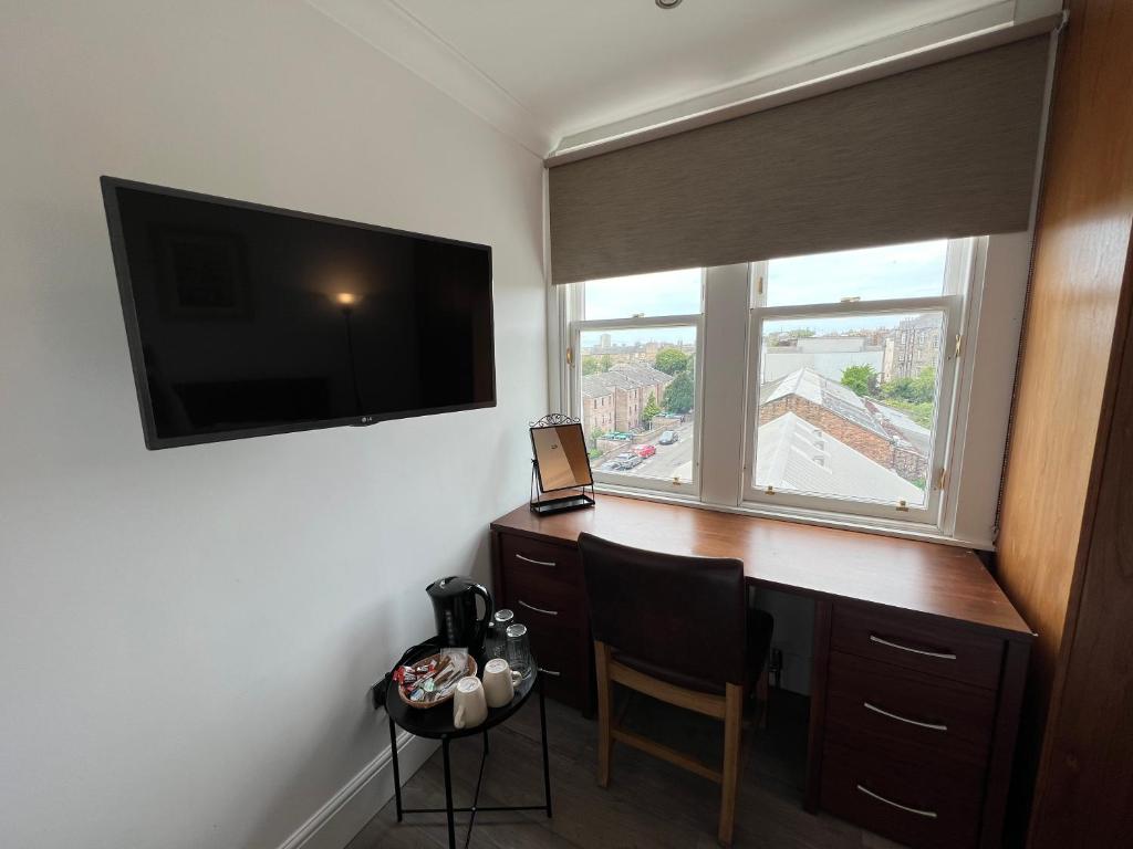爱丁堡Cosy Double Room City Centre的客房设有书桌、电视和窗户。