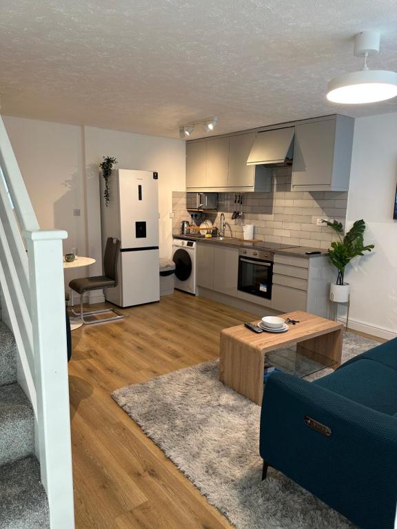 KentDartford Luxurious House with Parking - Netflix - Wi-Fi的一间带蓝色沙发的客厅和一间厨房