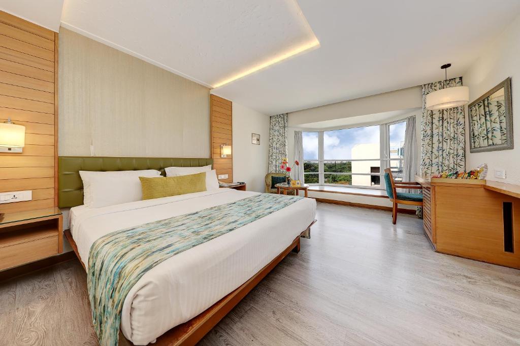 浦那中央公园酒店的一间卧室设有一张大床和一个大窗户