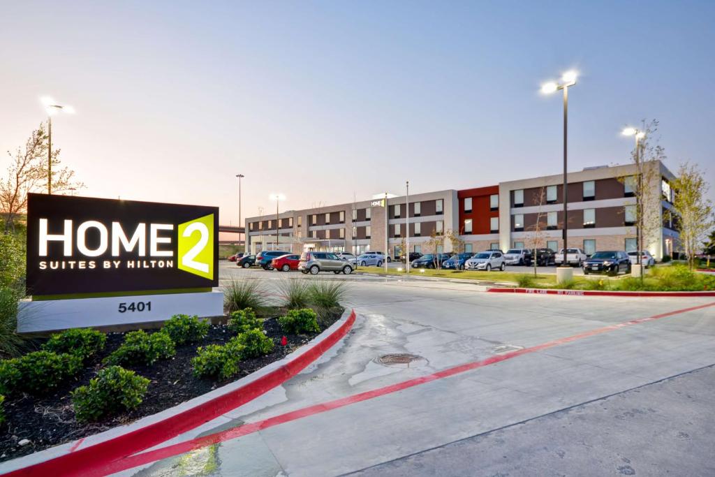 沃思堡Home2 Suites By Hilton Fort Worth Southwest Cityview的建筑物前停车场的标志