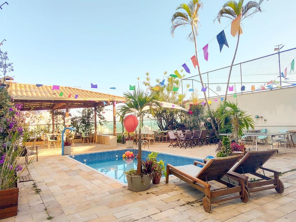 贝洛奥里藏特Éden Pampulha - Hotel Coworking的一个带两把椅子的庭院和一个游泳池