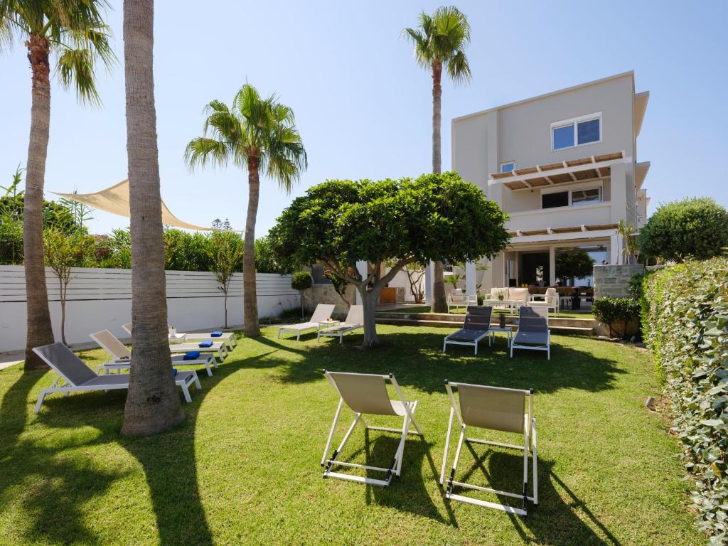 阿德里安诺斯坎波斯Sea La Vie的房屋前带椅子和棕榈树的草坪