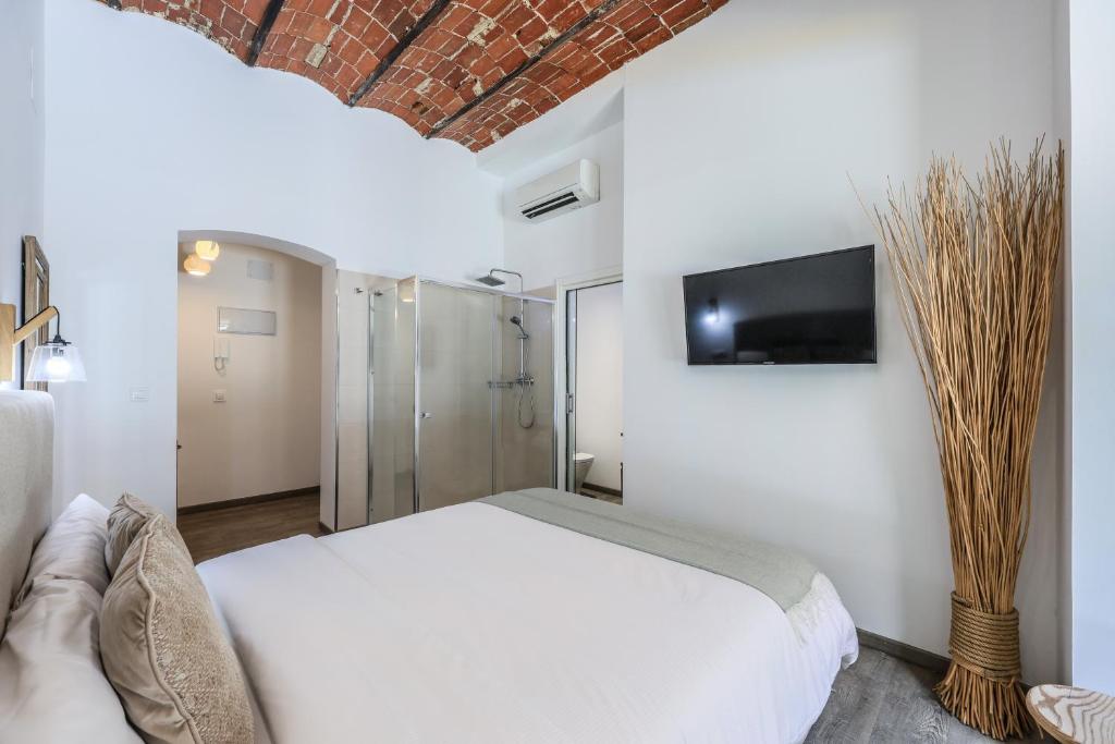马德里Puerta del Sol Apartamento economico的卧室配有白色的床和墙上的电视