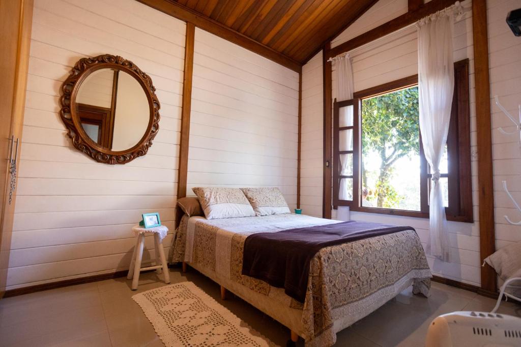 迈里波朗Cantareira - Deck House的一间卧室配有一张床、镜子和窗户