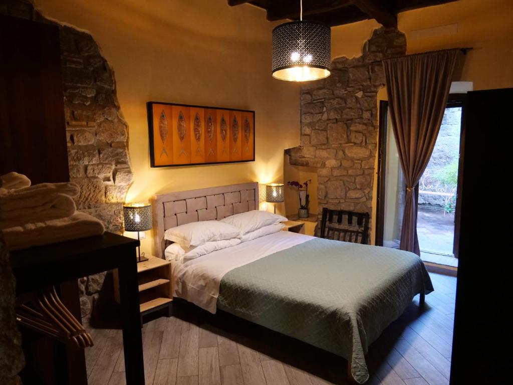 维泰博Al Cardinale的一间卧室配有一张床、一张桌子和一个窗户。