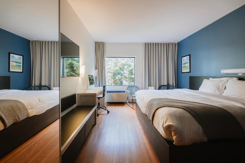圣亚森特达浦恩斯特哈斯恩特酒店的两张位于酒店客房的床,拥有蓝色的墙壁