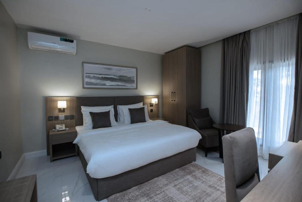 阿布贾Knightsbridge Hotel & Suites的酒店客房设有一张大床和一张书桌。