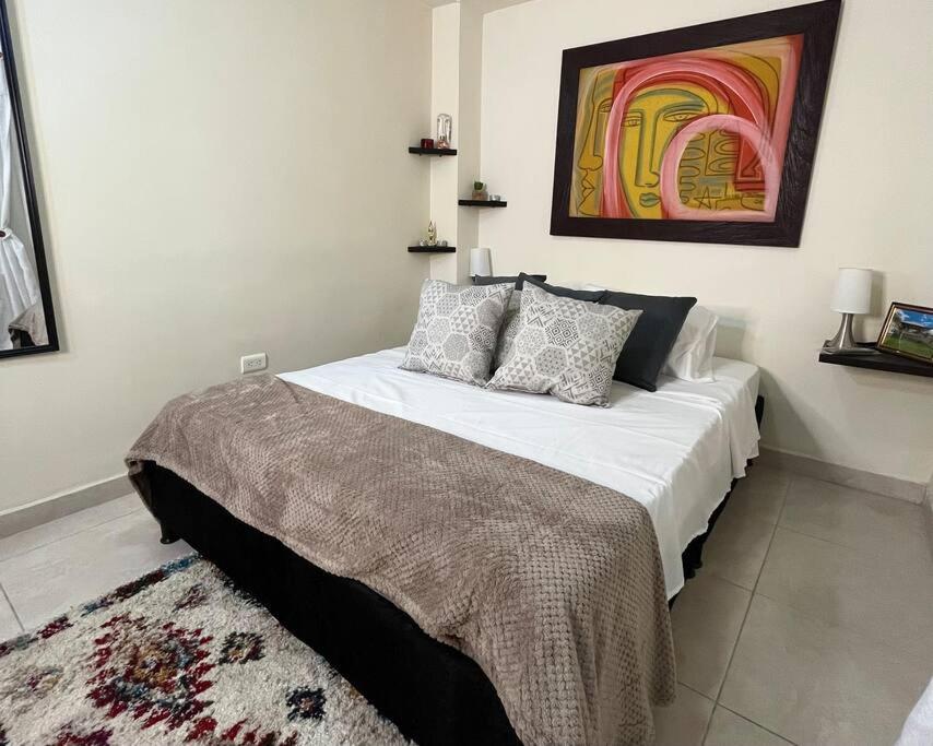 卡拉尔卡Apartamento cacique calarca的一间卧室配有一张壁画床